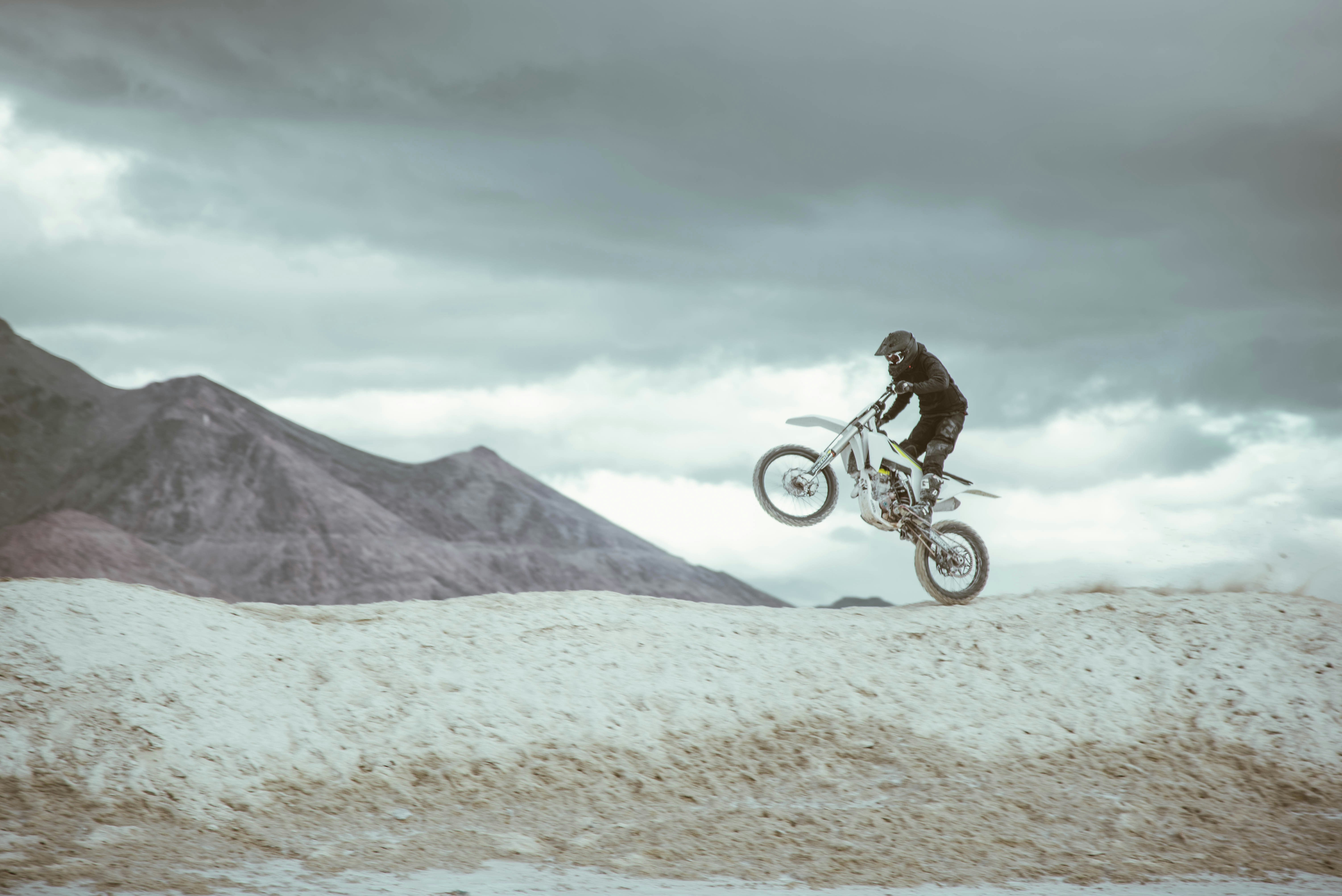 Dirtbike rider catching air on a desert trail